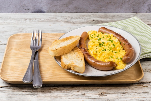 Scrambled eggs with sausages served on a plate