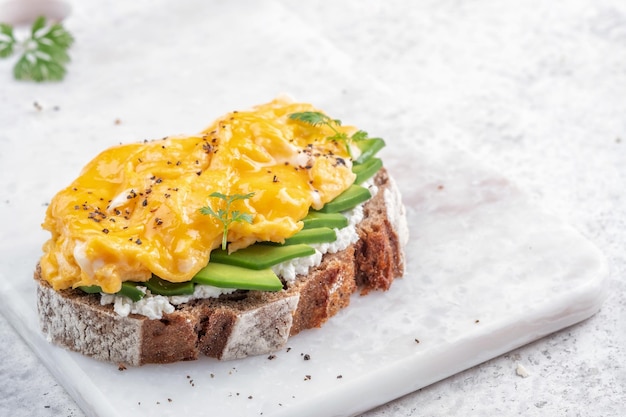 Photo scrambled eggs with smoked salmon cream cheese and avocado on toast