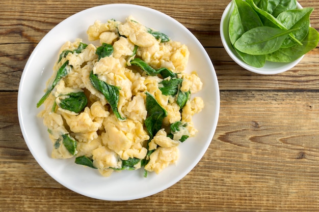 scrambled eggs with spinach in a white plate.