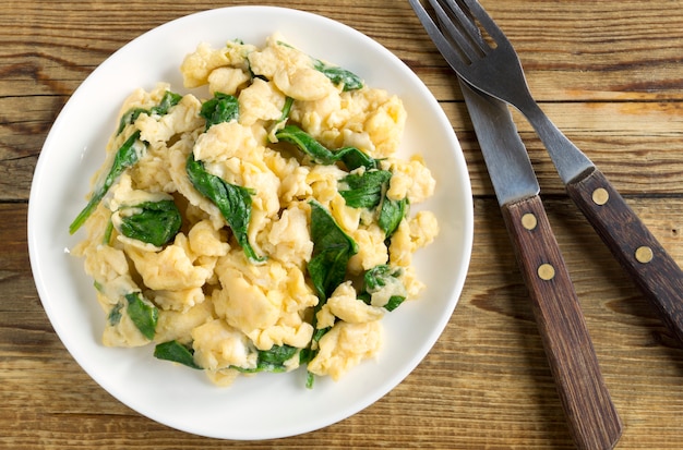 Uova strapazzate con spinaci in un piatto bianco.