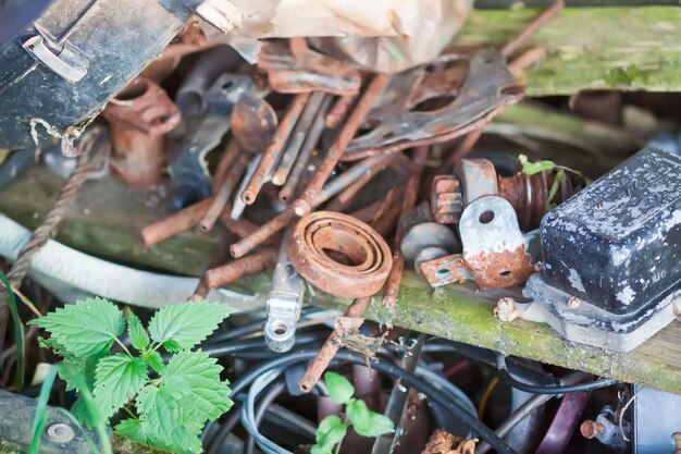 屋外の古い木のテーブルの上に積まれた金属スクラップさびた物体や道具