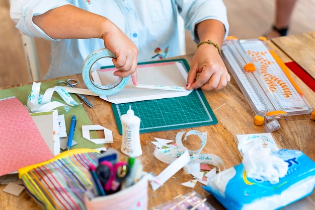 Scrapbook workshop Woman's hands applying adhesive tape