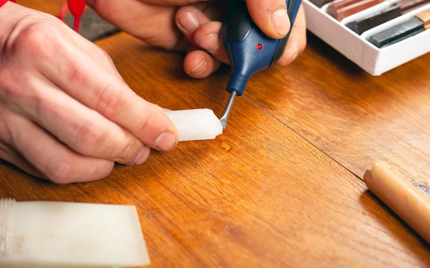 Scratch chipped restoration of laminate parquet and wooden furniture closeup