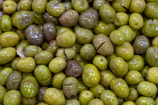 Scratched green olives Close up Green olives as background texture