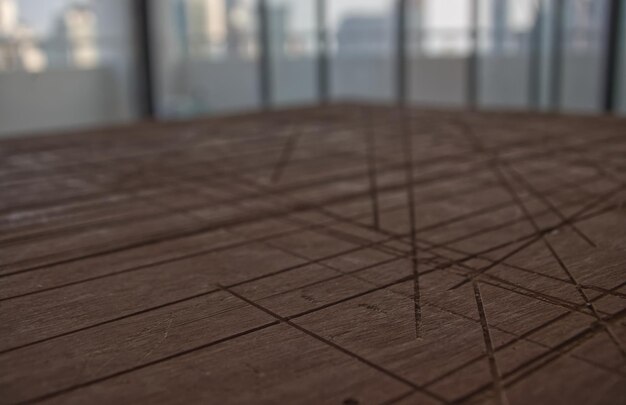 Scratched line on a wooden brown desk surface in a room