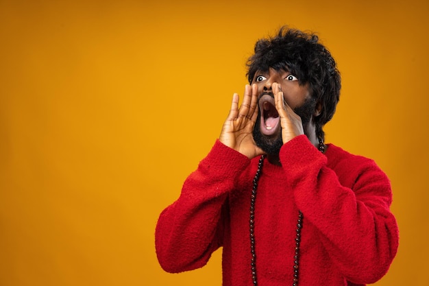 Screaming african american guy against yellow background