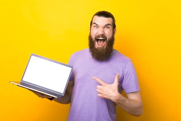 Screaming bearded man is pointing at the laptop