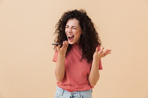 Foto urlando dispiaciuto giovane donna utilizzando il telefono cellulare.