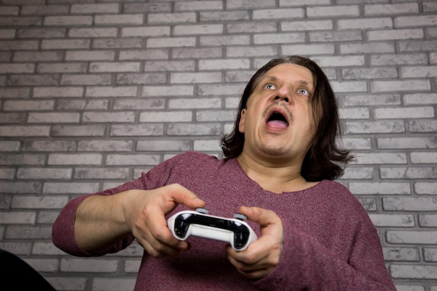 Screaming gamer shoots or attacks in computer game The concept of emotions Man playing computer game