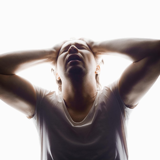 Foto screaming man in studio geïsoleerde witte achtergrond emotie jongen in een shirt cry