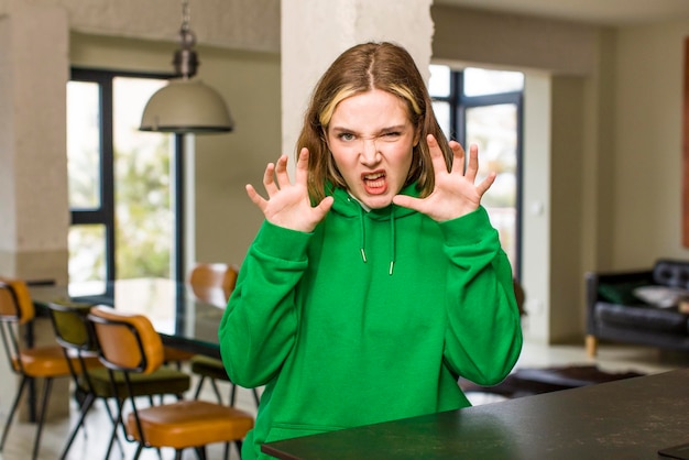 Photo screaming in panic or anger shocked terrified or furious with hands next to head