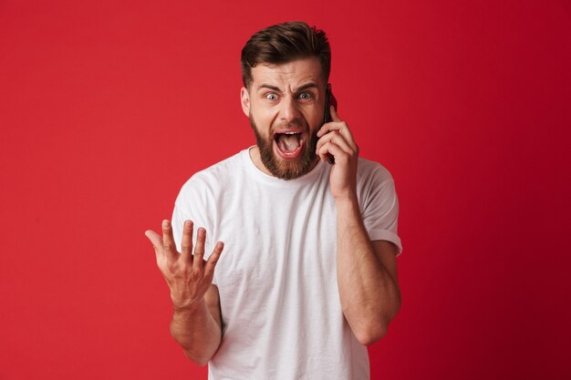 Screaming young man talking by mobile phone.