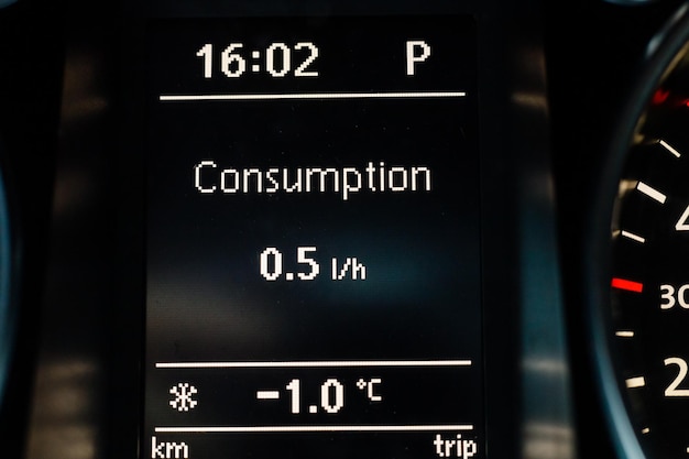 Screen on dashboard of car shows fuel consumption at idle and air temperature outside