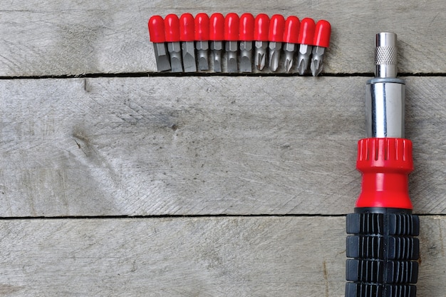 Screwdriver and bits on a wooden table. copy space