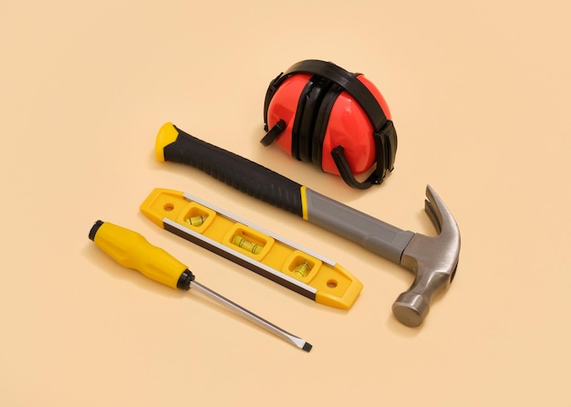 Photo screwdriver hammer headphones and yellow building level yellow bright set of construction tools