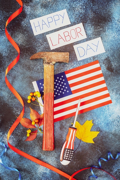 Blocco note aperto con cacciavite con scritta happy labor day e decorazioni natalizie con colori della bandiera americana