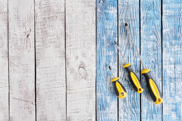 Photo screwdriver set on a wooden background top view copy space many screwdrivers on blue and gray old planks background