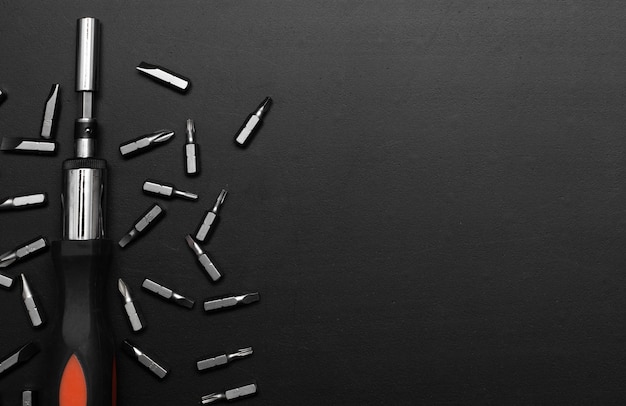 screwdriver tool on black table with accessories with space for text