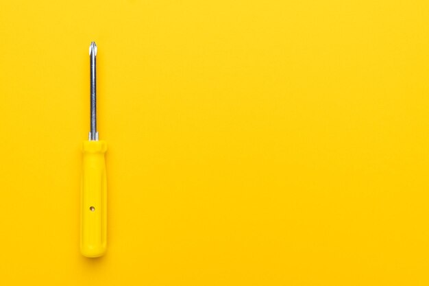 Photo screwdriver on yellow background