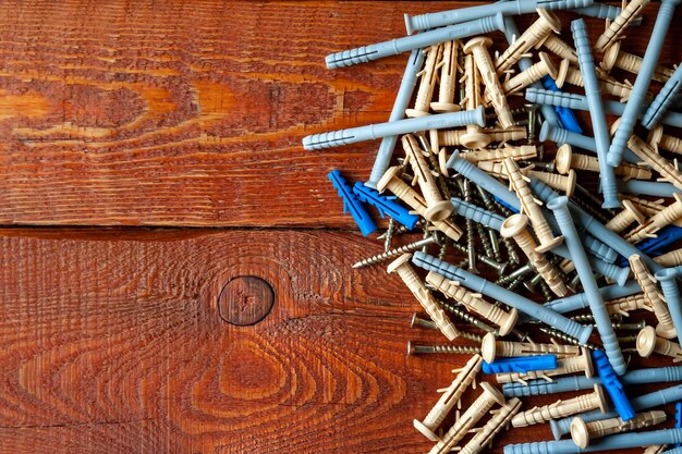Screws and plastic dowels on a wooden background Selective focus