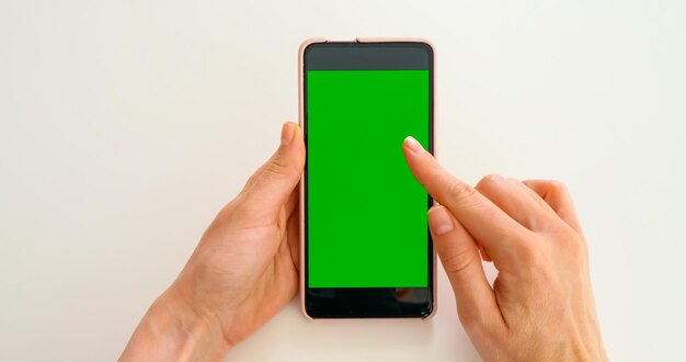 Foto scorrere sullo smartphone con green mock-up screen chroma key telefono schermo verde per il posizionamento del prodotto gesti su touch screen persona