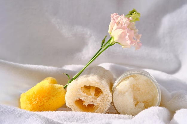 Scrub loofah washcloth and organic sea sponge on the towel