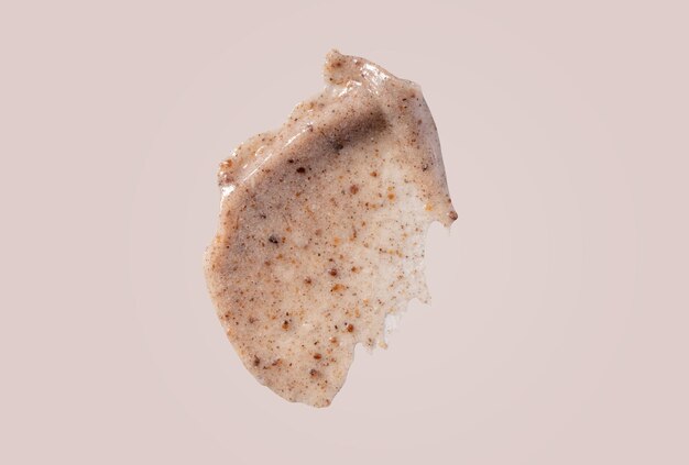 Photo scrub smear swatch isolated on beige background peeling cream smudge with exfoliating particles