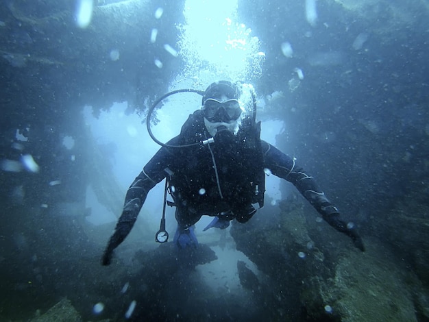 Photo scuba diver exploring the inside underwater shipwreck