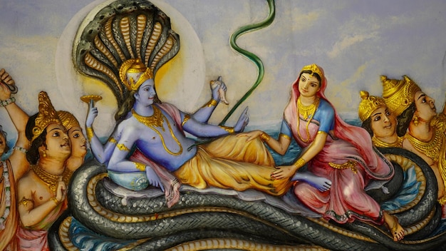 sculpture artwork of vishnu god sitting on his big snake