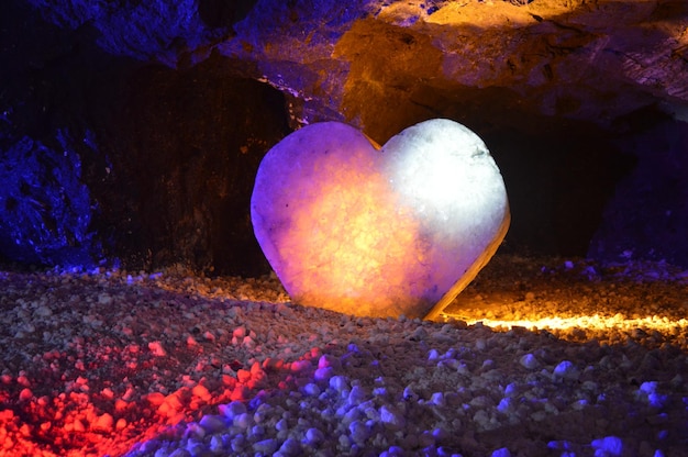 Скульптура сердца из соли, освещенная цветами