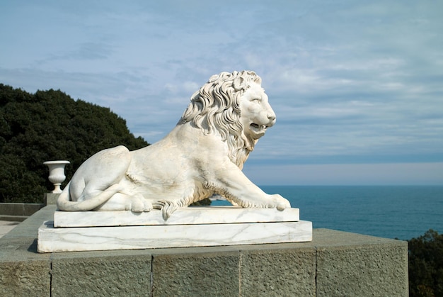 Скульптура льва на фоне моря