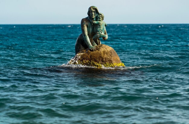 岩の上の海で、子供を腕に抱えた人魚の彫刻。ミショー、クリミア。
