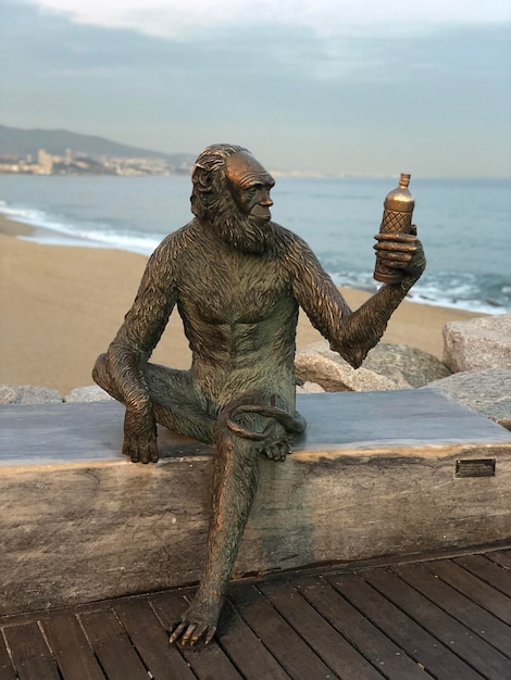 Foto scultura sul molo sulla spiaggia contro il cielo