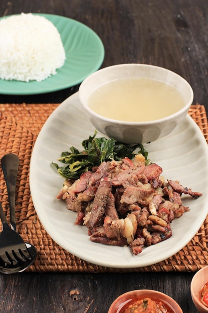 Se'i Sapi or  Beef Sei is Indonesia Traditional Smoked Beef, Served with Boiled Cassava Leaves and Sambal Luat or Sambal Matah. Typically Food from Nusa Tenggara, Indonesia