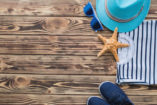 Sea background. Kid`s stuff on a wooden background. Flat still of child clothes.