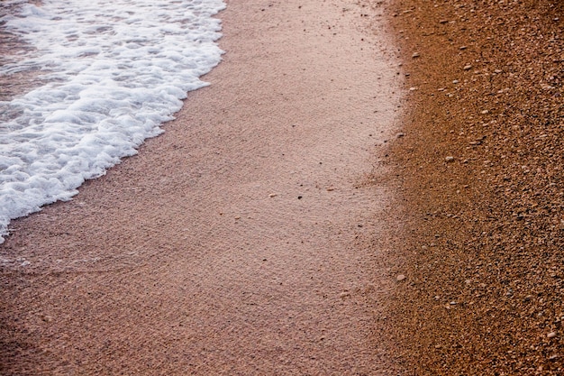 あなたのデザインのための砂と小さな砂利の海の背景