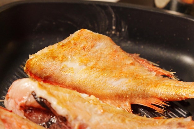 Sea bass sizzling away as theyre expertly grilled to perfection in a warm