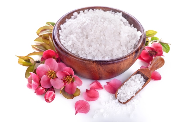 Photo sea bath salt in bowl and red blossom flowers on white background