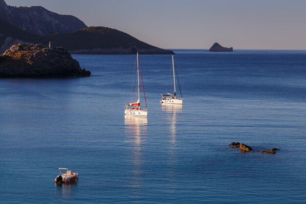 sea bay with yachts and boat in crystal clear azure water at Paleokastritsa corfu island Greece