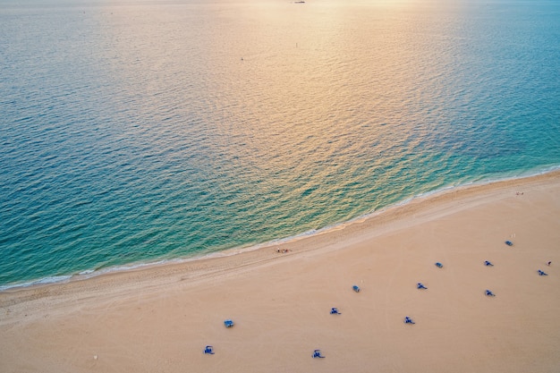 海のビーチ、空撮。上から見た砂浜と青い海の水。夏休みのコンセプト。ワンダーラスト、旅行、旅行。冒険、発見、旅。