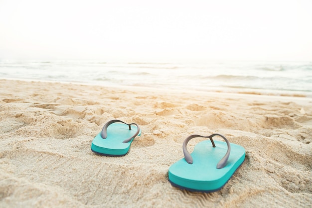 해변에서 바다 해변 모래에 샌들 신발에 발의 모래와 슬리퍼에 발자국 사람들