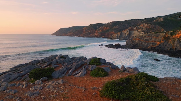 Sea beach sunset nature ocean waves splashing volcanic rocks seashore hills