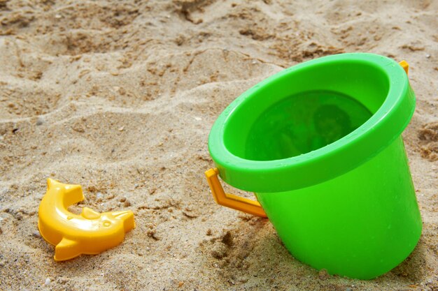 Photo on the sea beach with big green pail