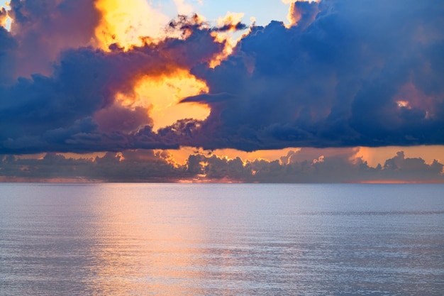 熱帯のビーチの自然の太陽の夕日の海の夕日の上に空の夕日または日の出の雲がある海のビーチ