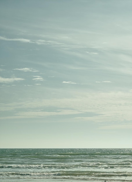 Sea under a beautiful cloudy spring sky on a bright sunny day Turquoise afternoon on the sandy beach of the Black Sea vertical frame