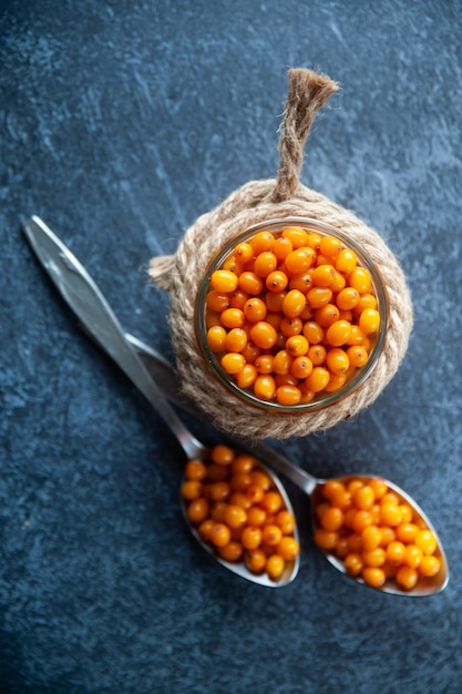 Sea buckthorn berries in a jar orange healthy berries macro top view