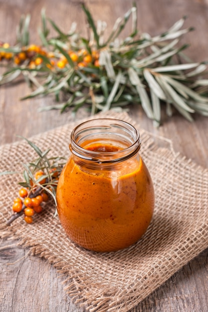 Sea buckthorn jam on old wooden background