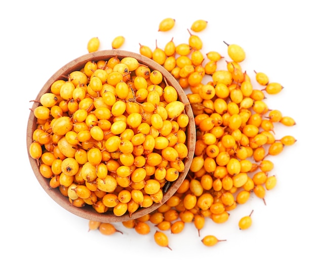 Sea buckthorn in a plate close-up on a white background, isolated. The view from top