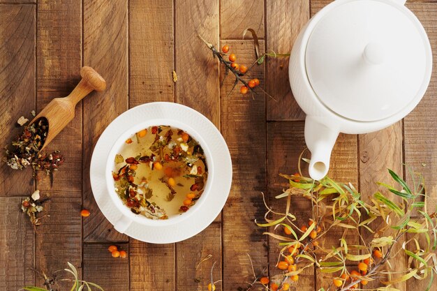 Sea buckthorn tea white porcelain on a wooden background