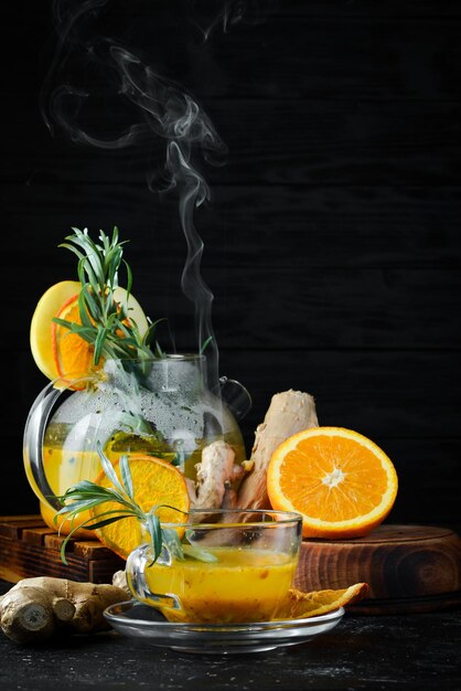 Sea buckthorn tea with orange and ginger Hot winter drinks On a black background Top view